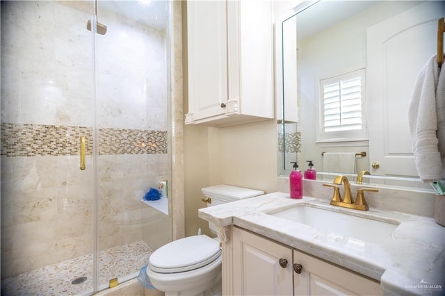 full bath with vanity, toilet, and a shower stall