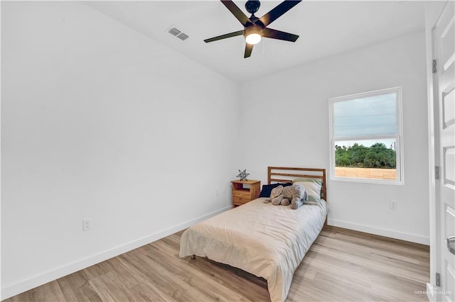 bedroom with a ceiling fan, baseboards, visible vents, and wood finished floors