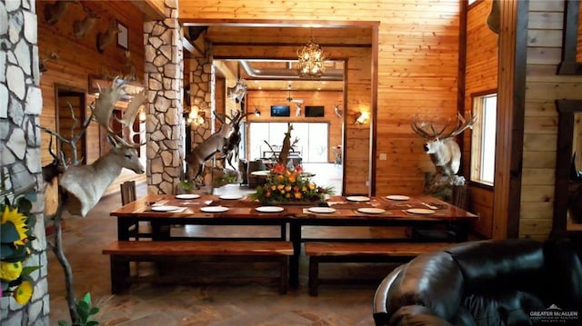 dining area with a notable chandelier and wooden walls