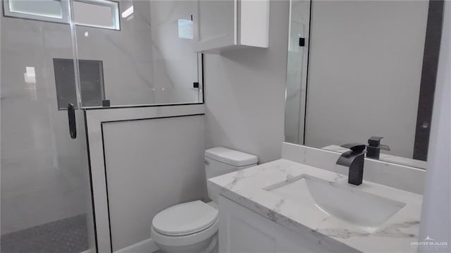 bathroom featuring vanity, toilet, and a shower with shower door