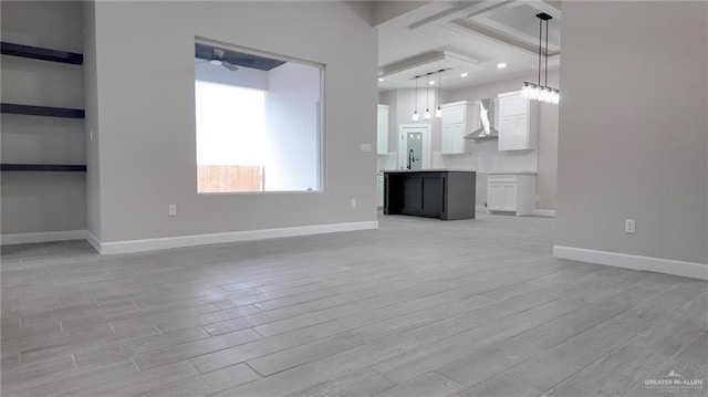 unfurnished living room featuring light hardwood / wood-style flooring, ceiling fan, and sink