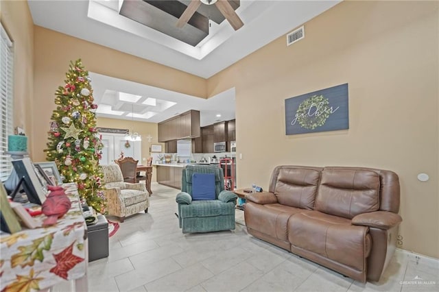 tiled living room featuring french doors and ceiling fan