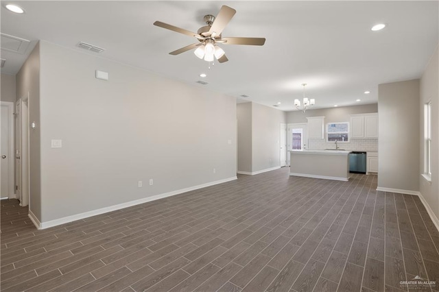 unfurnished living room with sink, dark wood-type flooring, and ceiling fan with notable chandelier