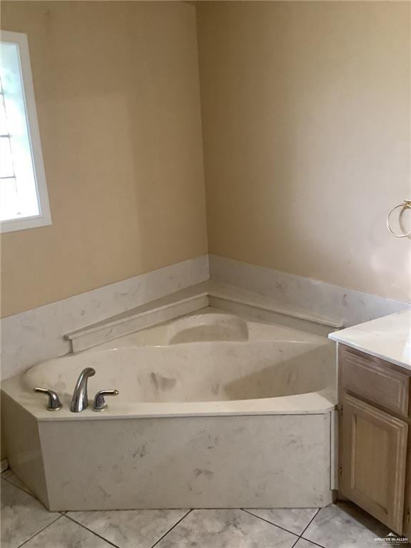 bathroom with tile patterned flooring, vanity, and a tub