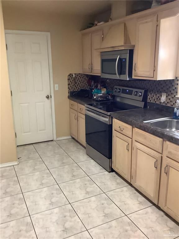 kitchen featuring decorative backsplash, light brown cabinets, and appliances with stainless steel finishes