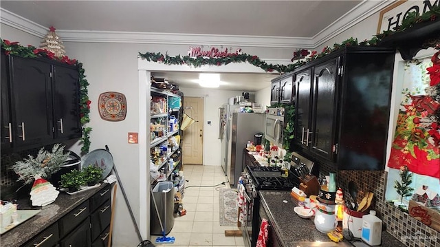 kitchen featuring light tile patterned floors, dark stone counters, stainless steel appliances, and crown molding