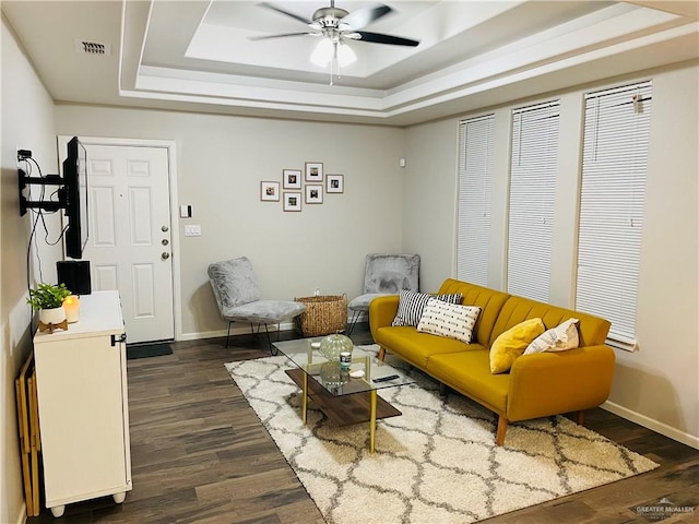 sitting room featuring dark hardwood / wood-style flooring, ceiling fan, and a raised ceiling