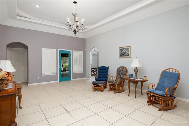 living area featuring a notable chandelier, a raised ceiling, and light tile patterned floors