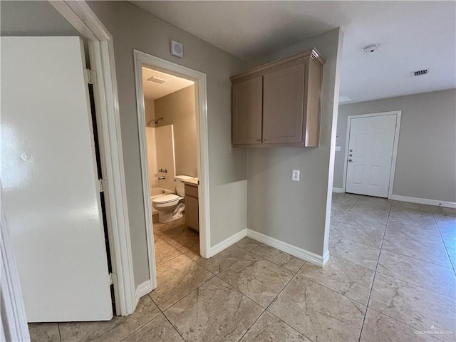 interior space with baseboards, bathing tub / shower combination, and toilet