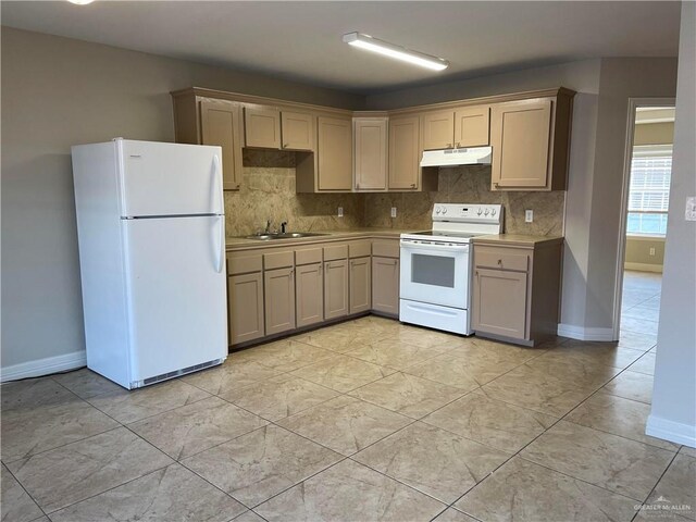 kitchen with white appliances, a sink, light countertops, under cabinet range hood, and backsplash