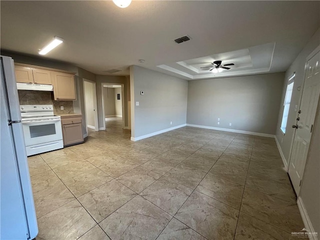 kitchen with under cabinet range hood, white appliances, visible vents, tasteful backsplash, and a raised ceiling