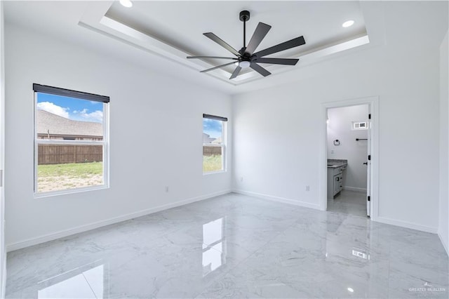 unfurnished bedroom with marble finish floor, baseboards, recessed lighting, and a raised ceiling
