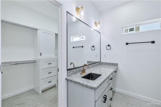 bathroom with baseboards, marble finish floor, and vanity