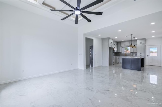 unfurnished living room with recessed lighting, baseboards, marble finish floor, a sink, and a ceiling fan