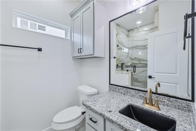 full bath with a marble finish shower, toilet, and vanity