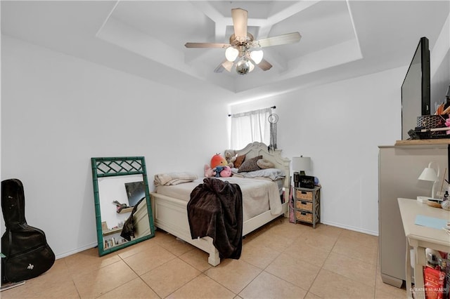 bedroom with a raised ceiling, light tile patterned floors, baseboards, and ceiling fan