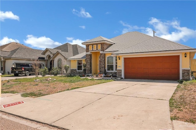 view of front facade featuring a garage, stone siding, concrete driveway, and stucco siding