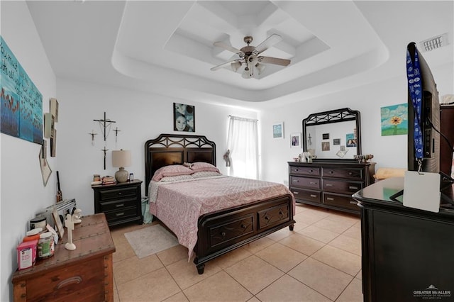 bedroom with a tray ceiling, visible vents, a ceiling fan, and light tile patterned floors