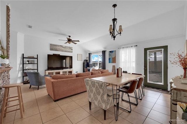 dining space featuring light tile patterned floors, visible vents, lofted ceiling, crown molding, and ceiling fan with notable chandelier