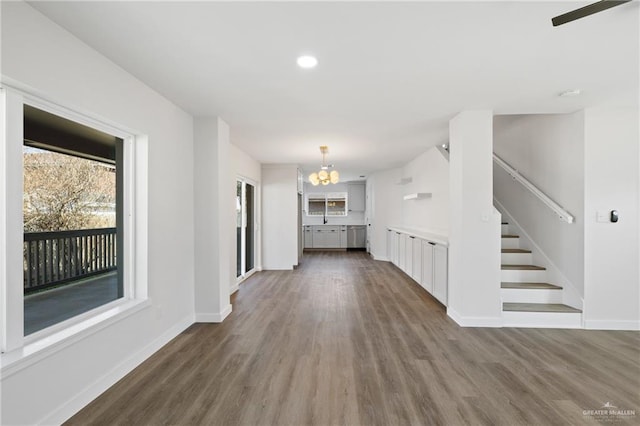 3400 Ozark Ave, Mcallen, TX 78504 - unfurnished living room with stairway, baseboards, an inviting chandelier, and dark wood finished floors