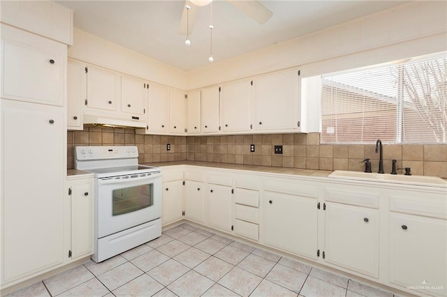 kitchen featuring white electric range, sink, white cabinetry, light tile patterned floors, and decorative backsplash