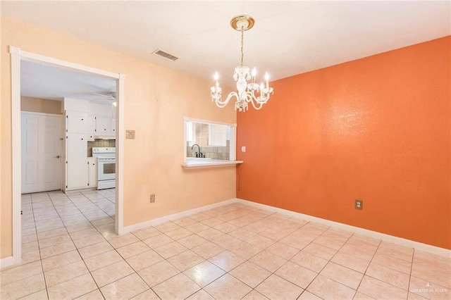 unfurnished dining area featuring ceiling fan with notable chandelier, sink, and light tile patterned floors