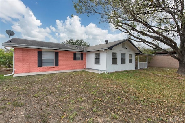 rear view of house featuring a patio and a yard