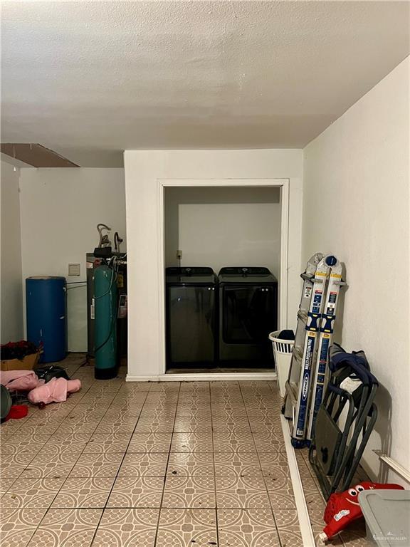 interior space featuring washer and dryer, tile patterned floors, and a textured ceiling