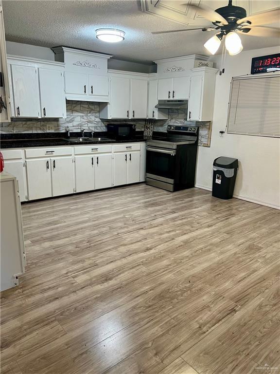 kitchen with white cabinets, backsplash, electric range, ceiling fan, and light hardwood / wood-style floors