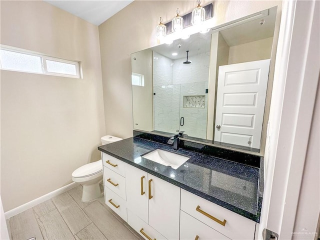 3100 E Zinnia Ave, Alton, TX 78573 - bathroom featuring a stall shower, toilet, vanity, and baseboards