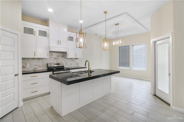 3100 E Zinnia Ave, Alton, TX 78573 - kitchen with stainless steel range with electric cooktop, a sink, under cabinet range hood, dark countertops, and tasteful backsplash