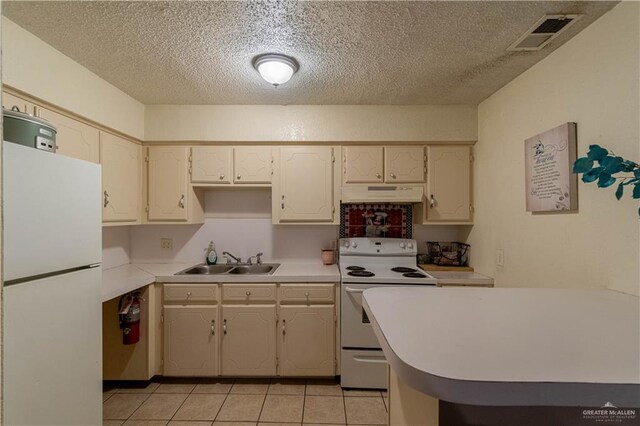 kitchen featuring a textured ceiling, white appliances, sink, and light tile patterned floors