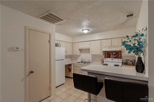 kitchen with white cabinetry, sink, a textured ceiling, white appliances, and light tile patterned floors