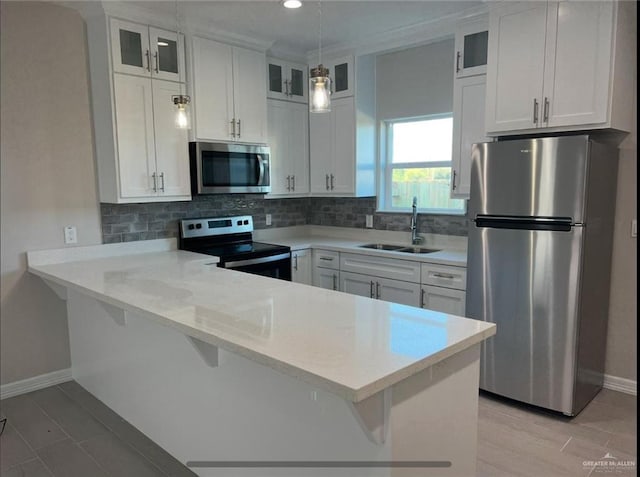 kitchen featuring stainless steel appliances, white cabinetry, a kitchen breakfast bar, and kitchen peninsula