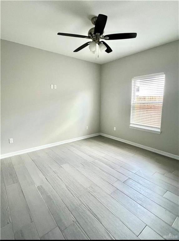 empty room with ceiling fan and light wood-type flooring