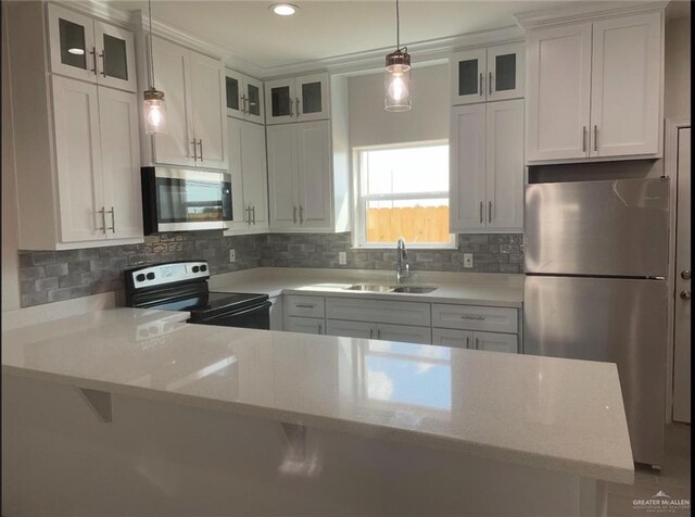 kitchen with appliances with stainless steel finishes, decorative light fixtures, sink, white cabinets, and decorative backsplash