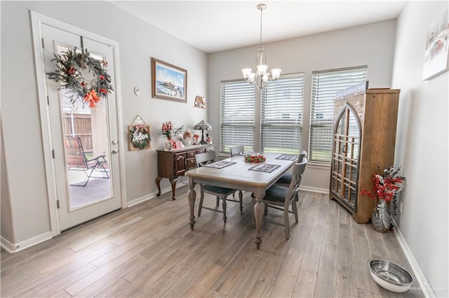 dining space with a chandelier and light wood-type flooring