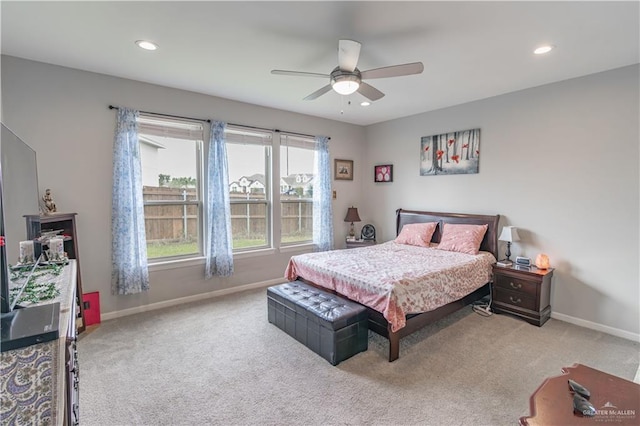 carpeted bedroom featuring multiple windows and ceiling fan