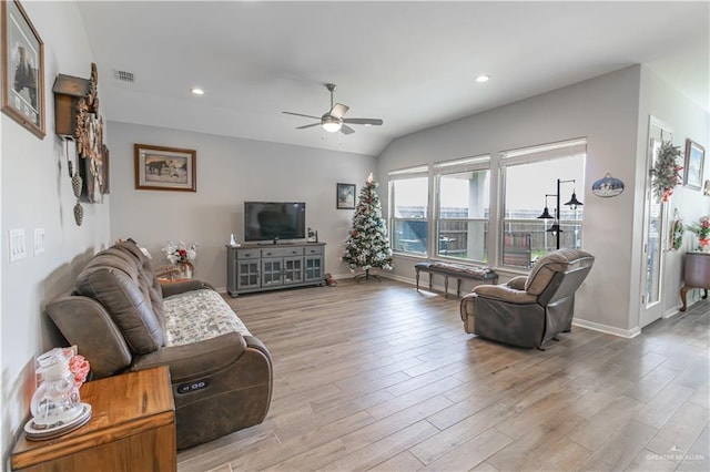 living room featuring vaulted ceiling, light hardwood / wood-style flooring, and ceiling fan