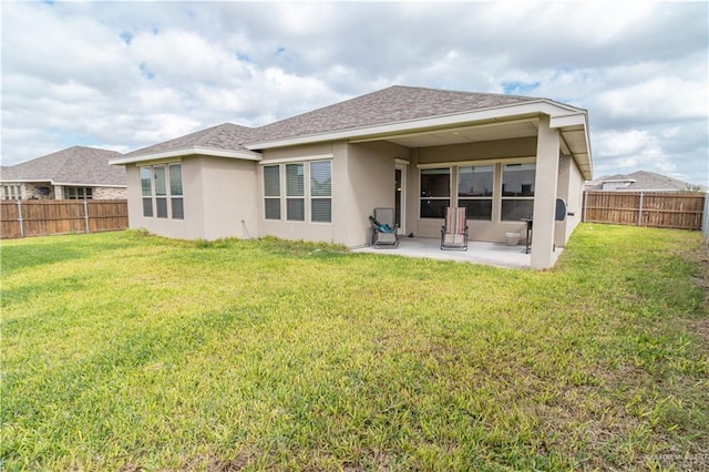 back of house with a patio area and a lawn