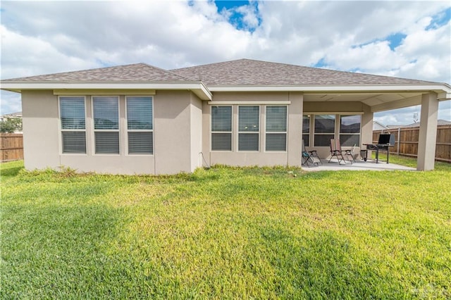 back of house featuring a lawn and a patio