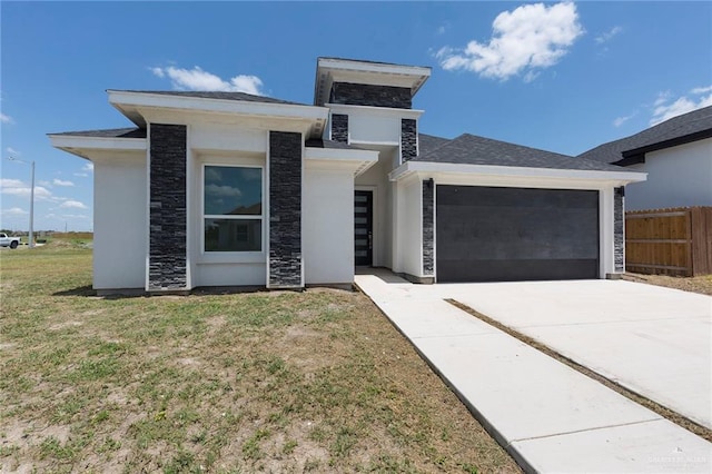 contemporary house featuring a front yard and a garage