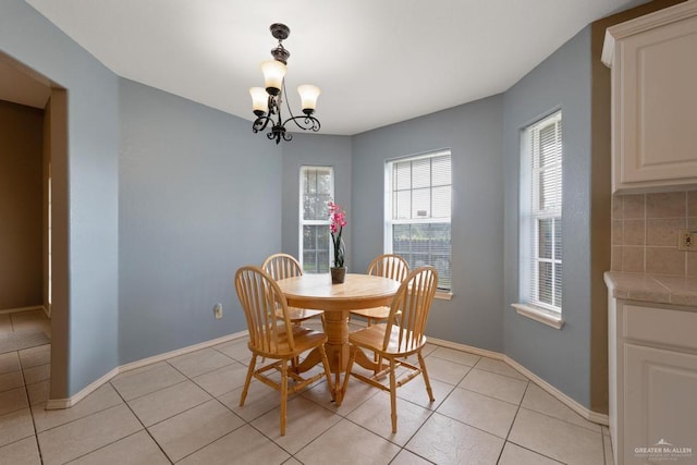 dining area featuring light tile patterned floors and a notable chandelier