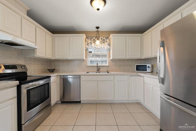 kitchen featuring appliances with stainless steel finishes, backsplash, decorative light fixtures, and sink