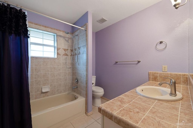 full bathroom featuring toilet, vanity, tile patterned floors, and shower / bathtub combination with curtain