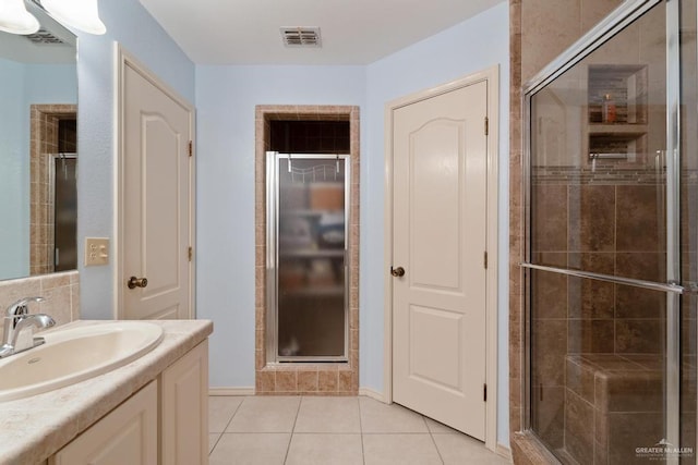 bathroom with tile patterned flooring, vanity, and an enclosed shower