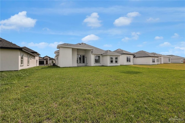 1015 Magnolia St, Mission, TX 78573 - back of house featuring a yard and stucco siding