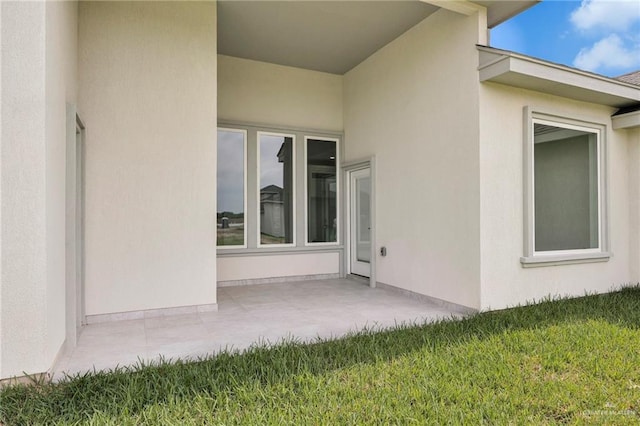 1015 Magnolia St, Mission, TX 78573 - entrance to property featuring stucco siding, a patio, and a lawn