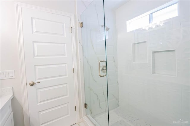 bathroom with a notable chandelier, vanity, and walk in shower