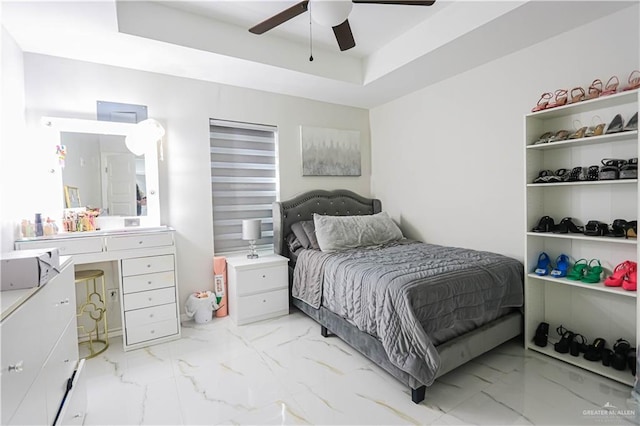 bedroom featuring ceiling fan and a tray ceiling